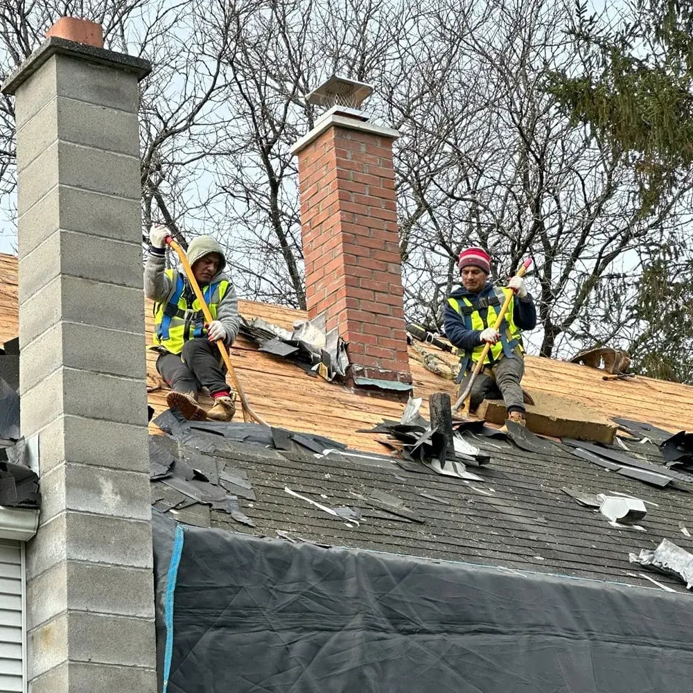 a couple of men working on a roof