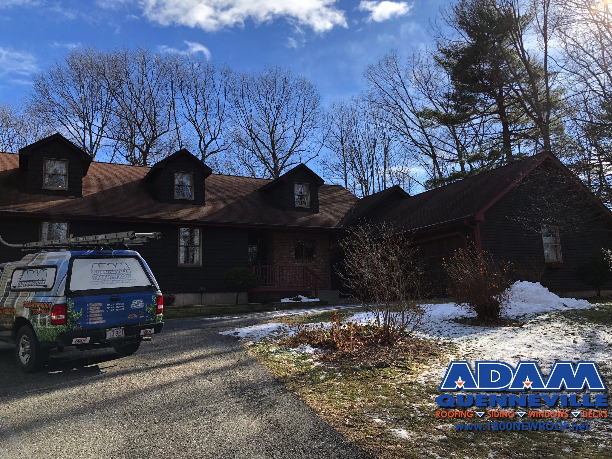 This is a photo of a completed roofing and riding replacement project with brown shingles.
