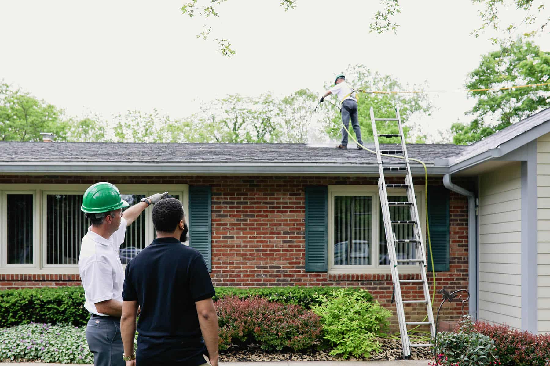 homeowner watching RoofMaxx being applied to their roof