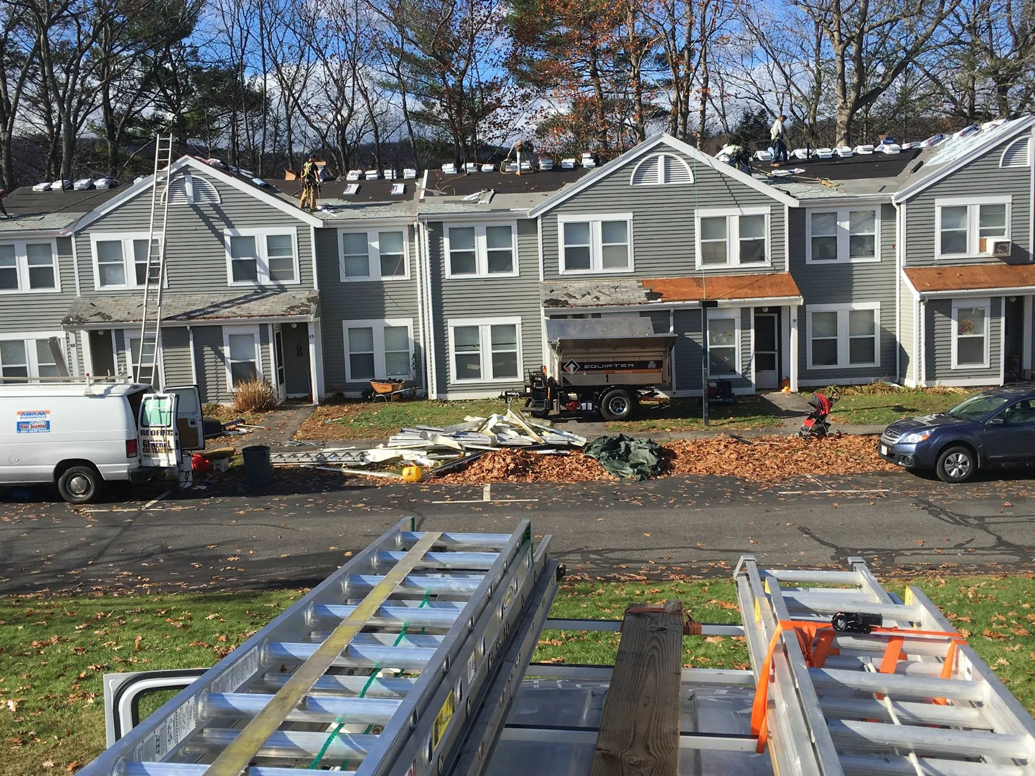 a row of houses with ladders and a truck in front of it