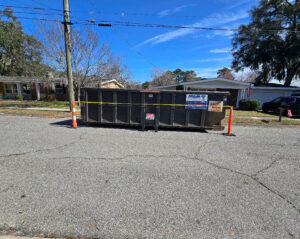 dumpster for roofing materials parked on the street