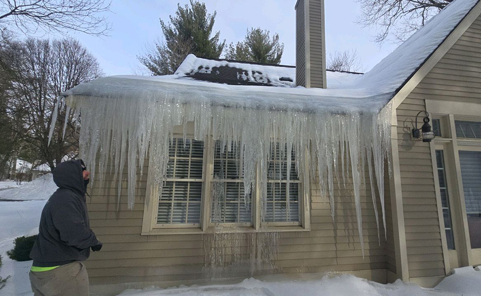 an ice dam causing a sheet of icicles down the entire side of the home