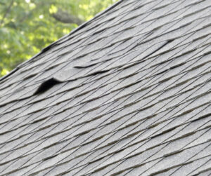a roof with some shingles that have lifted, causing a gap