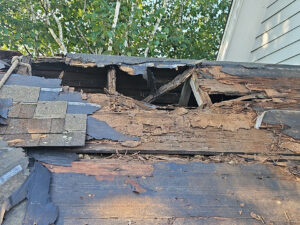 a roof showing severe damage to the roof deck, with several sections missing