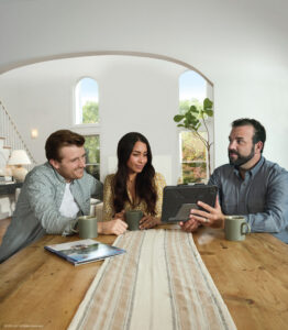 homeowners at dining room table with contractor, explaining shingle options